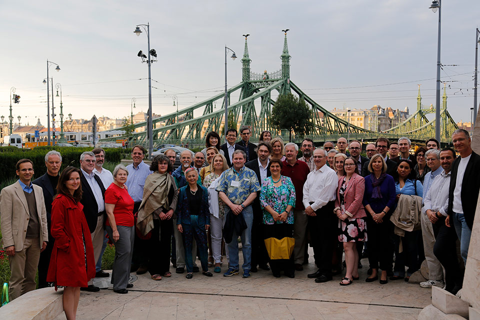 Some 40 people stand up to a photography with a beautiful bridge in the background